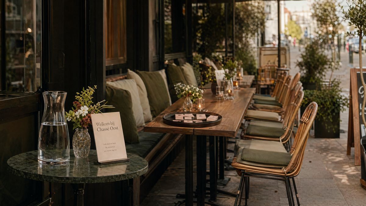 Welkom bij Chassé Oost — terras met linnen kussens en warme details.