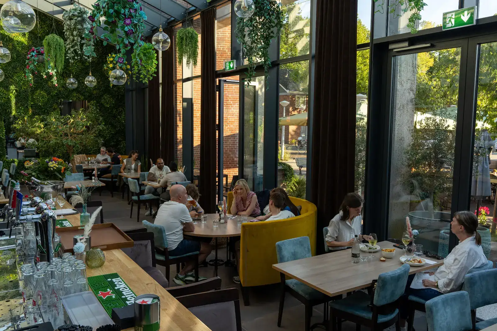 Gasten aan tafel in de lichte serre van Brasserie Lenny in Amsterdam Oost